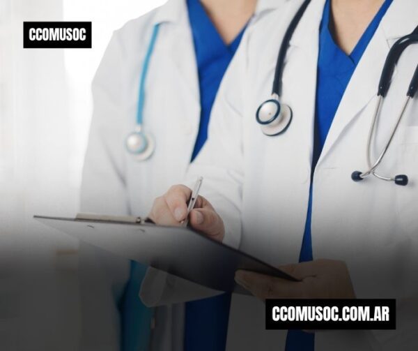 Dos médicos con bata blanca y estetoscopio revisan una historia clínica en una carpeta