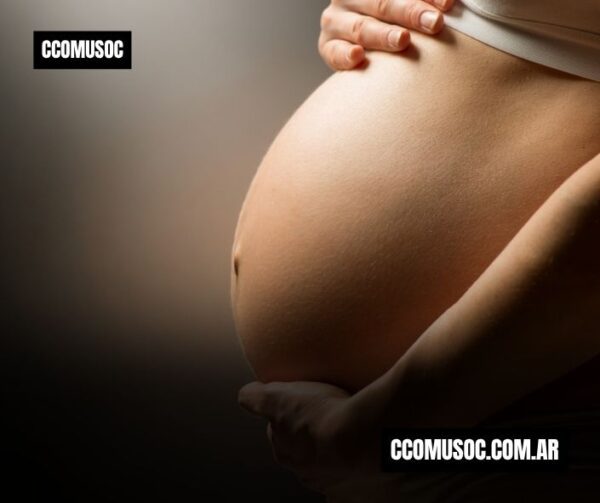 Mujer embarazada sujetándose el vientre con las manos