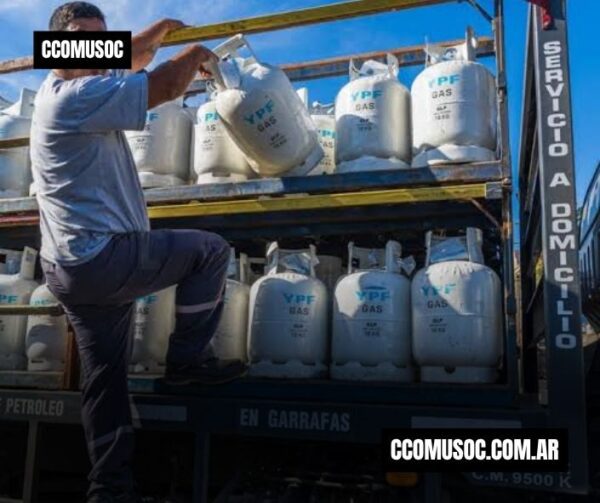 Camión cargado con garrafas de gas y un hombre acomodándolas