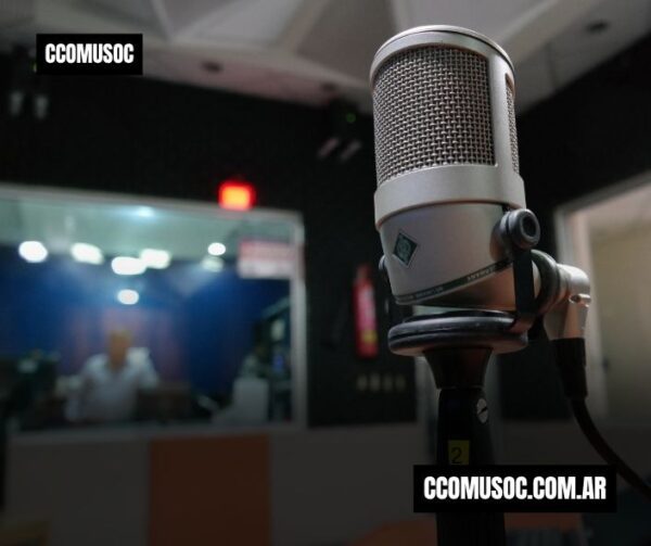 Micrófono de estudio en primer plano con una cabina de grabación al fondo