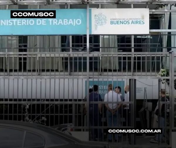 Ministerio de Trabajo de Buenos Aires visto tras una reja, con varias personas reunidas en la entrada