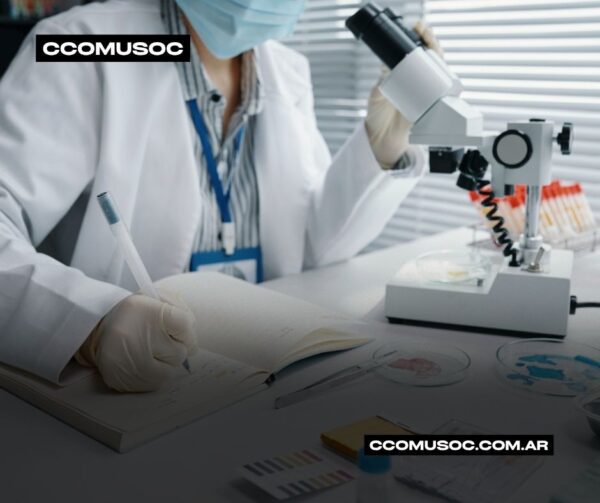 Científica con bata y guantes usando un microscopio en un laboratorio