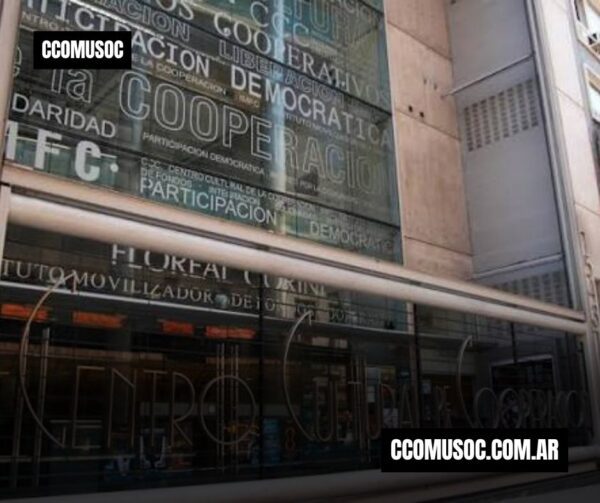 Fachada de un edificio con grandes palabras sobre cooperación, democracia y participación; aparece el sitio ccomusoc.com.ar