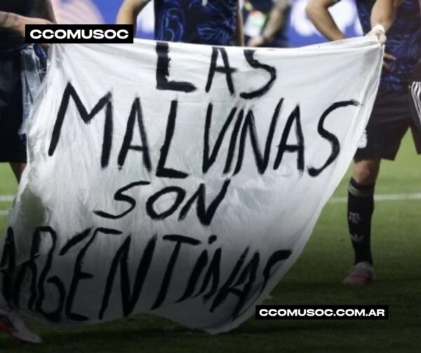 Pancarta con el mensaje “Las Malvinas son argentinas” sostenida por varias personas en un campo de fútbol