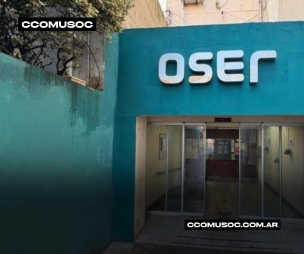 Entrada de la sede de OSER con fachada turquesa y puertas de vidrio abiertas